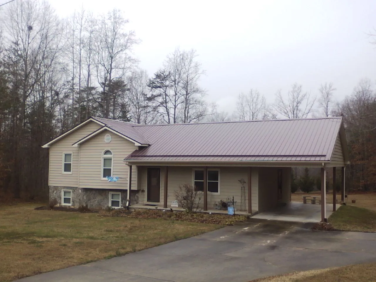 Burgundy metal roof on a tan split level home with an attached carport in Springfield